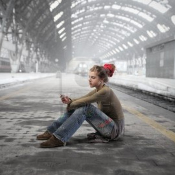 8656321 jeune femme assise sur le quai d 39 une gare et en utilisant un telephone mobile