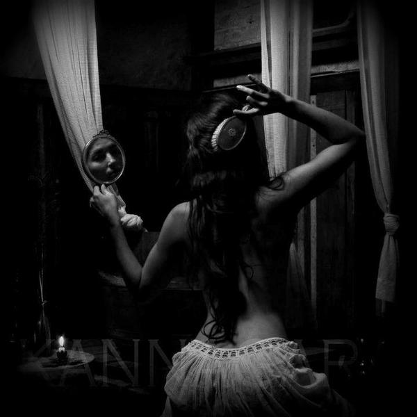 Femme se brosse les cheveux boucles brune de dos visage dans miroir de courtoisie photo noir et blanc