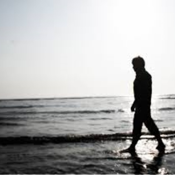 Homme marchant dans la mer