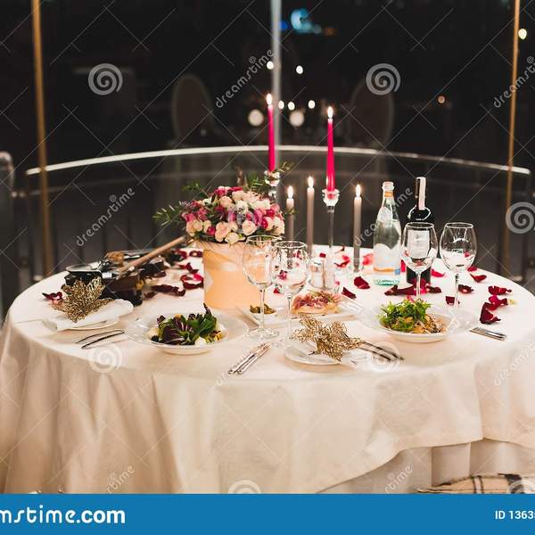 Arrangement romantique de table avec du vin belles fleurs dans la bo%c3%aete verres vides p%c3%a9tales rose et bougies 136355355